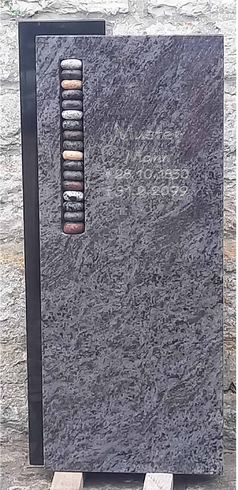 Dunkler Grabstein mit Kieseleinlage