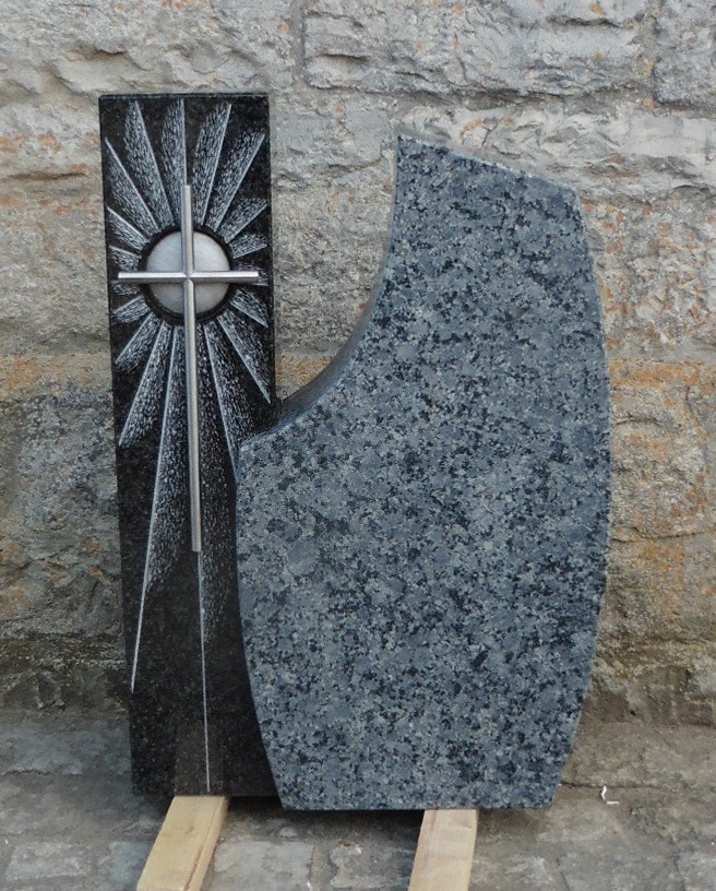 Grauer Grabstein mit Kreuz und Strahlenmotiv