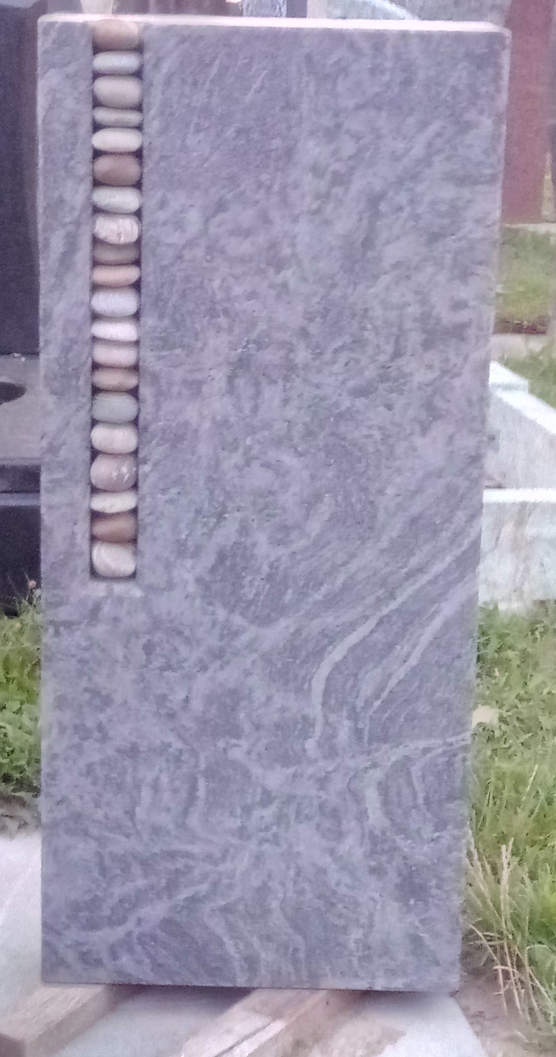 Grauer Grabstein mit Kieselstein-Einlage