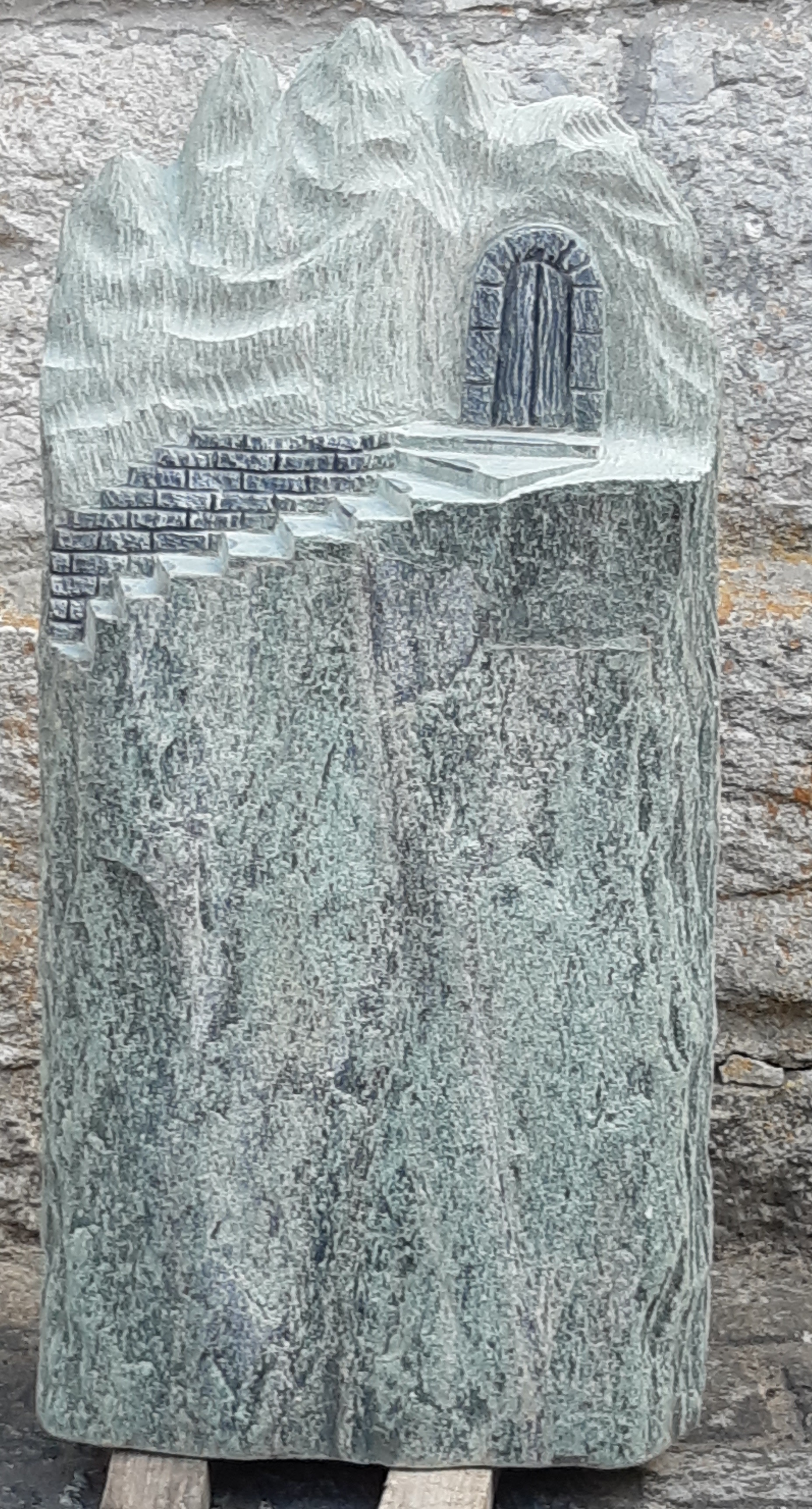 Grüner Grabstein mit Treppen- und Türrelief