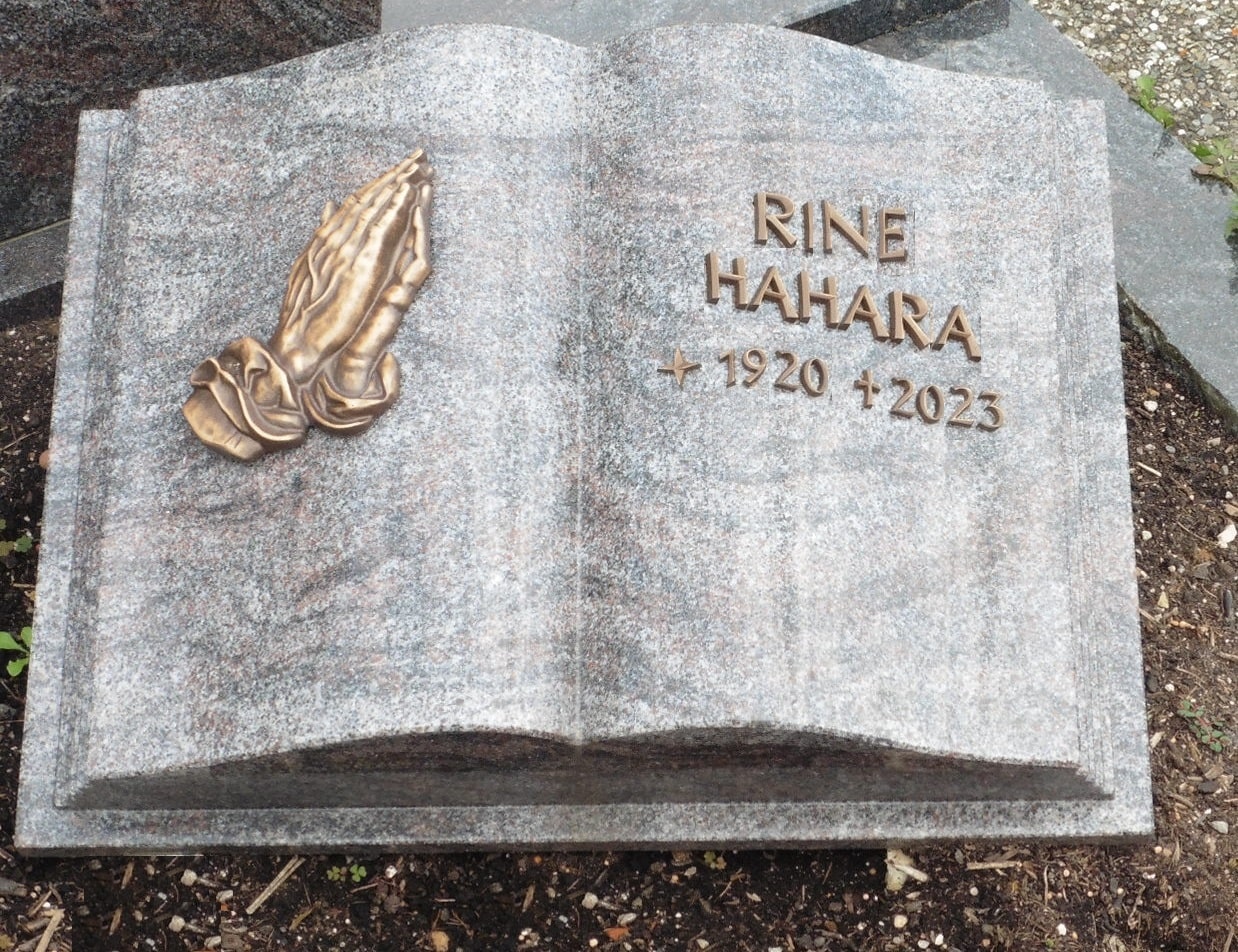 Grabmal in Buchform mit betenden Händen