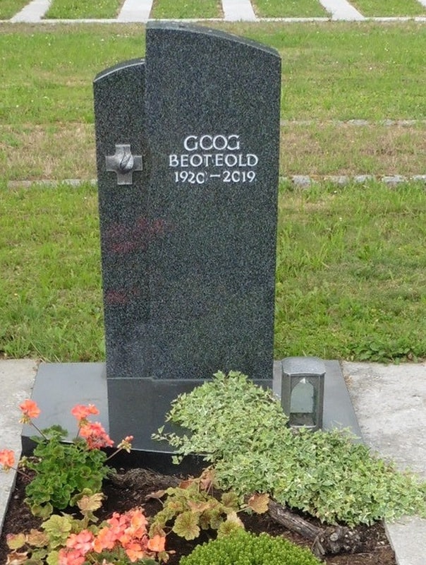 Schlichter dunkler Grabstein mit Kreuz