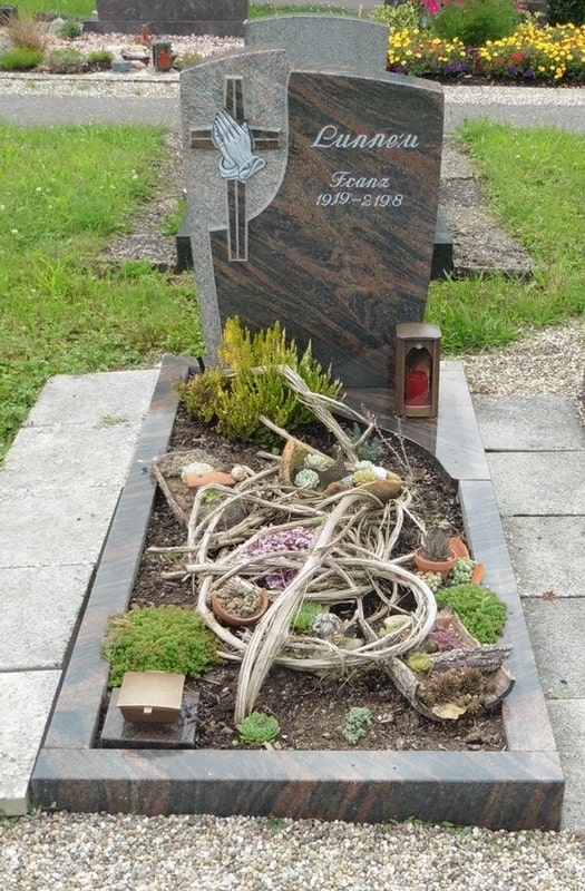 Rötlich-brauner Grabstein mit betenden Händen
